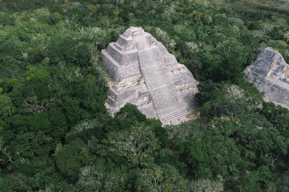 Vista aérea de una pirámide maya de piedra clara rodeada de selva densa en Campeche, sin personas