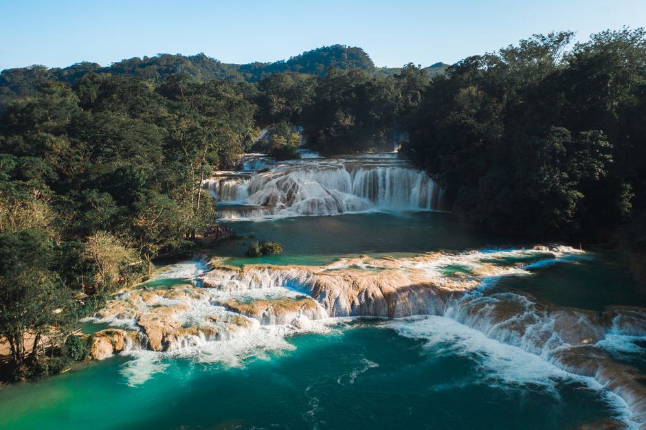 Vista aérea de cascadas de agua blanca sobre pozas turquesa rodeadas de selva, en las cascadas de Agua Azul, Chiapas, sin personas visibles
