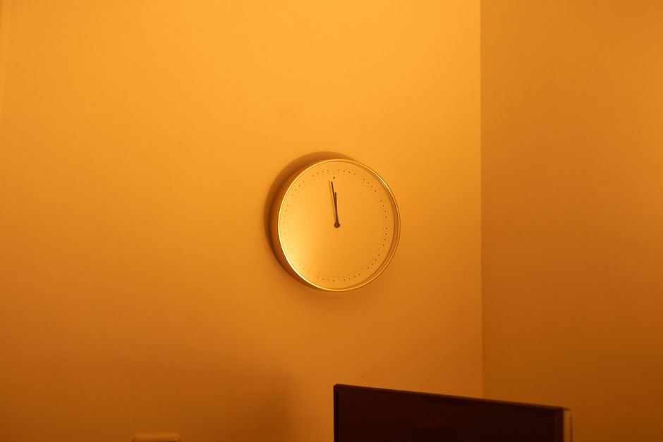 Reloj de pared sin números sobre una pared de color naranja cálido